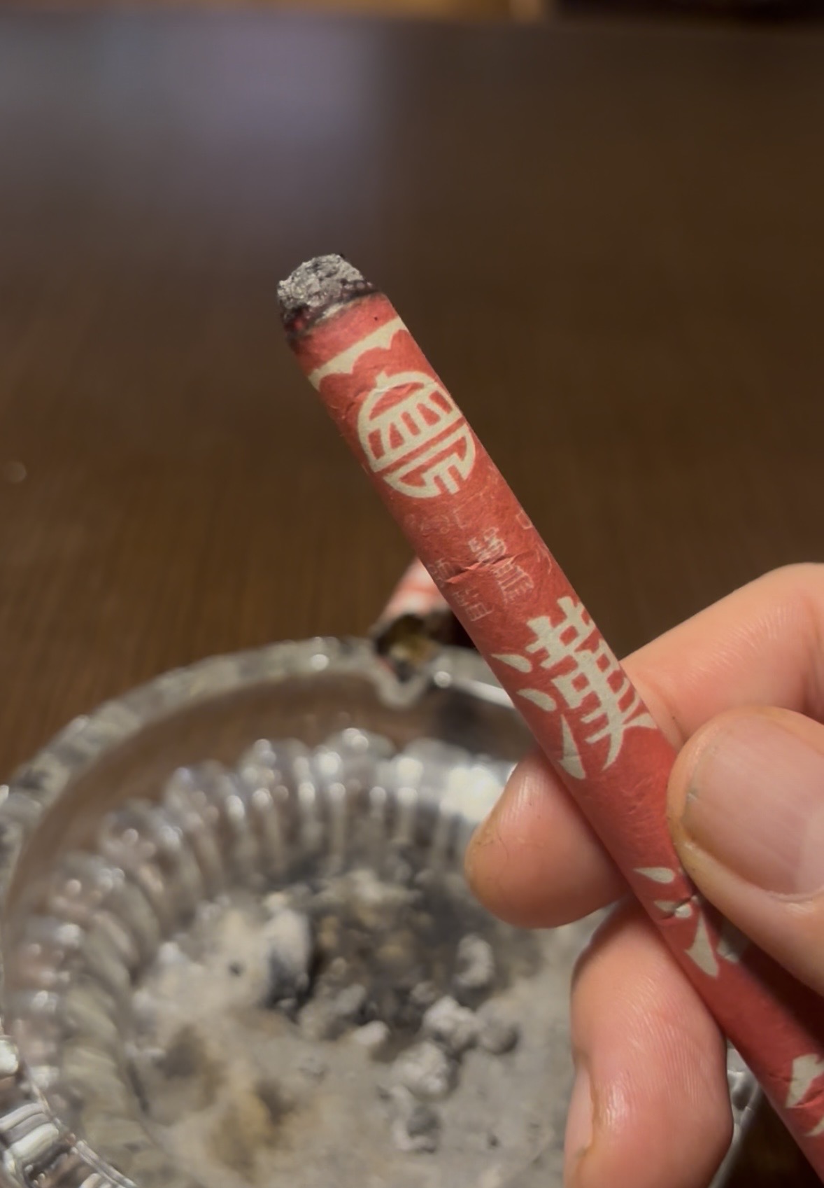 火のついた漢法灸を手に持っている実物写真。内容量は11本入りです
